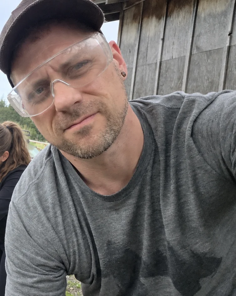 Joshua outdoors wearing safety glasses during a woodworking project