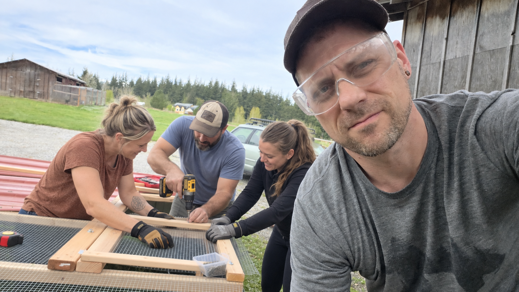 Joshua with three people building a wooden frame outdoors